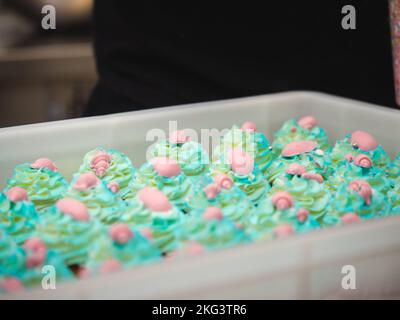 chef pâtissier préparant un bouquet de petits gâteaux givrés sur le thème de la mer turquoise vert Banque D'Images