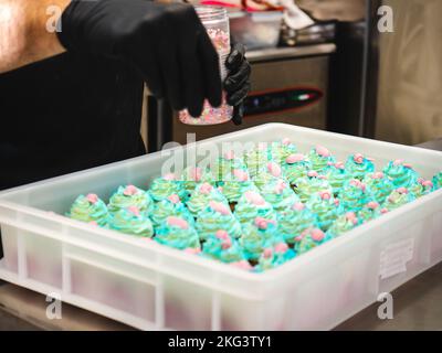 chef pâtissier préparant un bouquet de petits gâteaux givrés sur le thème de la mer turquoise vert Banque D'Images