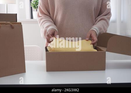 Femmes emballage carton boîte colis pour la vente en ligne. Femme vendeur prépare la boîte de livraison. Banque D'Images