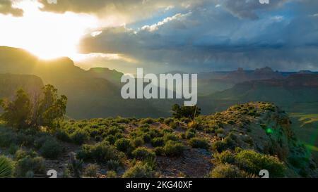 Le coucher du soleil projette des derniers faisceaux de lumière sur le Grand Canyon alors qu'une tempête se profile à l'horizon Banque D'Images