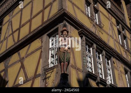 Le Drapier, une figure de poste en bois sculpté d'un marchand de tablier ou de tissu début 1600s, donne sur la rue des Marchands dans le coeur historique de Colmar, Alsace, Grand-est, France, de la Maison zum Kragen (maison du Collar) à pans de bois, construit en 1419 mais reconstruit en 1588 après son effondrement. Banque D'Images