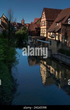 Le restaurant Caveau Saint-Pierre, dans une maison typiquement alsacienne de 16th siècles à pans de bois, se reflète dans la surface ondulée de la rivière Lauch canalisée, qui serpente à travers la petite Venise historique (la petite Venise) à Colmar, Alsace, Grand est, France. Banque D'Images