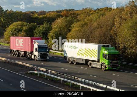 Deux poids lourds, Waitrose et un camion (Ocean Network Express) voyageant le long de l'autoroute M3, Angleterre, Royaume-Uni Banque D'Images
