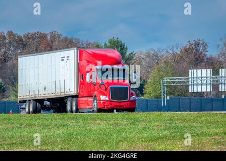 Photo horizontale d'un dix-huit roues rouge et blanc sortant d'une autoroute inter-États. Banque D'Images