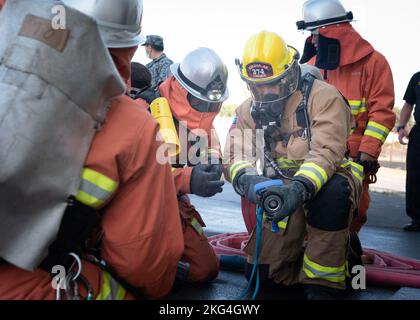 Un pompier de la Force aérienne japonaise d'autodéfense, à gauche, enseigne à Airman la classe 1st Jeremy linger, pompier du 374th Escadron de génie civil, à droite, comment utiliser un tuyau d'incendie japonais lors d'un entraînement bilatéral à la base aérienne de Yokota, au Japon, le 28 octobre 2022. Les 374 ces et JASDF s'exercent ensemble chaque année pour donner aux deux une chance d'apprendre les uns des autres en essayant différents équipements et méthodes de prévention des incendies. Banque D'Images