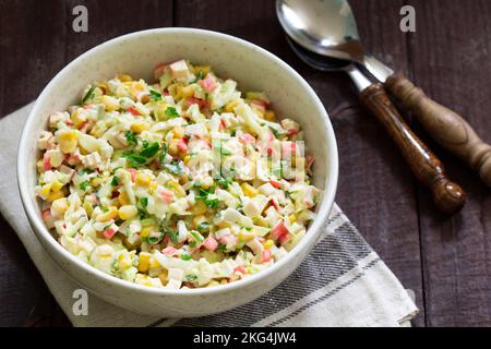 Salade de légumes avec bâtonnets de crabe, garnie de mayonnaise. Banque D'Images