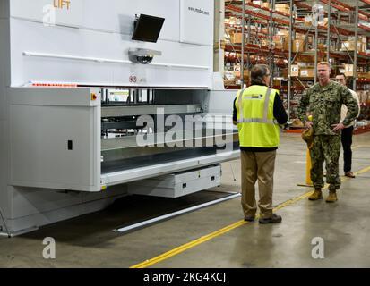 Le Capitaine Cory Schemm, commandant du NAVSUP FLC San Diego, parle avec un employé de Modula des modules de levage vertical Modula à l'entrepôt intelligent 5G situé sur la Naval Air Station North Island Oct. 28. Entrepôt intelligent 5G, NAVSUP, NAVSUP FLC San Diego, Banque D'Images