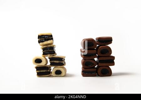 Piles de bonbons à la réglisse noir et blanc sur fond blanc Banque D'Images