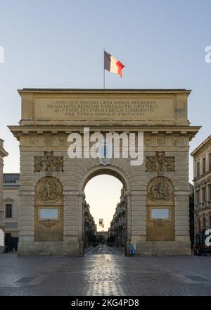 En début d'été, vue du matin sur l'Arc de Triomphe ou l'arche triomphale, monument historique avec drapeau français, célèbre monument de Montpellier, France Banque D'Images