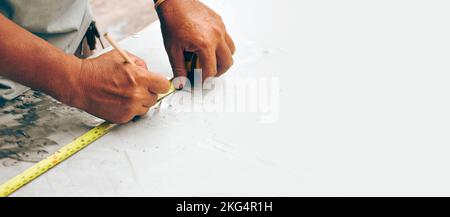 Le technicien mesure la longueur de la plaque métallique avec un mètre ruban et écrit la distance avec un crayon dans l'usine , bannière panoramique wi Banque D'Images