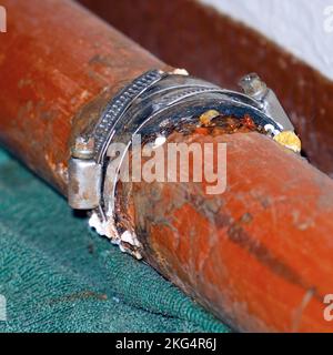 Fixer le raccord sur un tuyau d'eau qui fuit. Mise au point sélective Banque D'Images