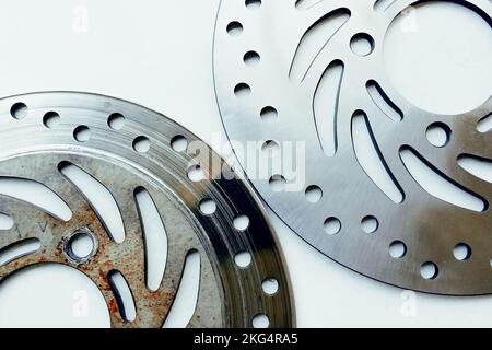 Comparer les disques de frein de moto neufs et anciens, les objets sur fond blanc Banque D'Images
