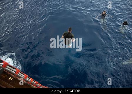 221030-N-XN177-2284 WESTERN PACIFIC OCEAN (OCT 30, 2022) – Aviation Boatswain's Mate (Fuels) 2nd Anthony Castanon, de long Beach, Californie, affecté au transporteur d'assaut amphibie USS Tripoli (LHA 7) saute dans l'eau pendant un appel de natation le 30 octobre 2022. Tripoli opère dans la zone d'opérations de la flotte américaine 7th afin d'améliorer l'interopérabilité avec ses alliés et ses partenaires et de servir de force de réaction prête à l'emploi pour défendre la paix et maintenir la stabilité dans la région Indo-Pacifique. Banque D'Images