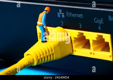 Image conceptuelle d'une figure miniature qui étudie un défaut sur un câble réseau large bande Banque D'Images