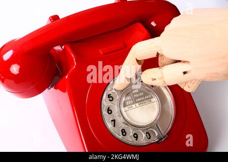 Main en bois utilisant un rétro rétro vieux téléphone rouge cadran Banque D'Images
