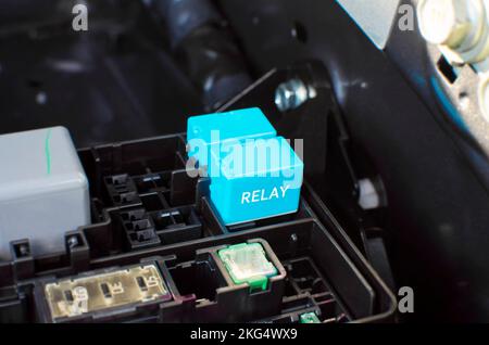 Le relais électronique de la voiture dans la fente de la boîte à relais sur le compartiment moteur, concept de pièces automobiles Banque D'Images