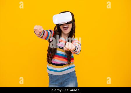 Adolescent stupéfié. Portrait de la jeune fille dans un casque VR, isolé sur le jaune. Joueur jouant aux jeux VR, aux jeux VR. Jeune fille excitée. Banque D'Images