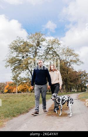 Un couple heureux marche leur chien dalmation Banque D'Images