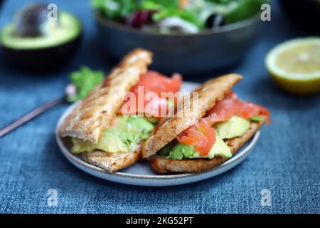 Sandwich au saumon avec avocat et laitue. Banque D'Images