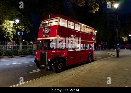 Un bus londonien classique à impériale rouge est stationné la nuit sur la place du Parlement à Londres Banque D'Images