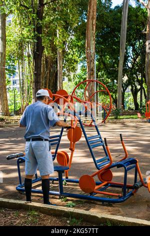 Un vieil homme s'entraînant avec un équipement de fitness en plein air au Parque Rosinha Cadar à Belo Horizonte, Brésil. Banque D'Images