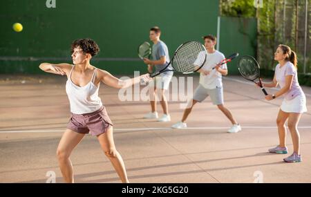 Femme sportive en short et t-shirt jouant frontenis sur le terrain Banque D'Images
