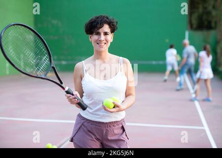 Portrait d'une femme latino debout sur le terrain de frontenis, tenant la raquette et le ballon Banque D'Images