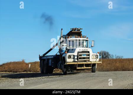 2017 11 30 Oklahoma USA - ancien camion de Mack en fonctionnement avec des phares entorchés et cassés fait un virage sur une route de gravier avec des pâturages d'hiver à distance Banque D'Images