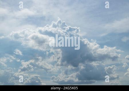 Ciel bleu avec des nuages moelleux qui ressemblent à un dinosaure ou à un dragon qui souffle le feu Banque D'Images