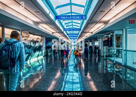 Jume 20 2022 Tulsa OK USA - couloir de l'aéroport avec puits de lumière et des panneaux indiquant que le temps est un Jetplane - homme dans le sac à dos passant le salon militaire - Une famille wa Banque D'Images