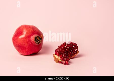 Fruits mûrs à la grenade sur fond rose Banque D'Images