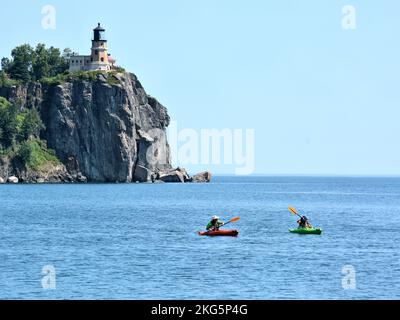 Deux kayakistes pagayez sur le lac supérieur avec l'emblématique phare de Split Rock en arrière-plan Banque D'Images