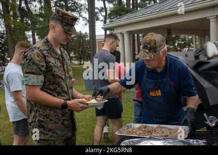 Un bénévole de l’Alliance militaire de la Chambre de commerce de New Bern sert de la nourriture à un Marine américain à l’automne 2022 Chicken Pickin’ on Marine corps Air Station Cherry point, Caroline du Nord, Oct. 5, 2022. L'événement a permis aux membres du service de se rassembler et de profiter de la nourriture et de la musique gratuites. La New Bern Chamber of commerce Military Alliance a préparé et servi plus de 100 poulets aux militaires et à leurs familles. Poulet Pickin’, MCAS Cherry point, Marine corps, Marines, New Bern Chamber of commerce Military Alliance, Fun, Banque D'Images