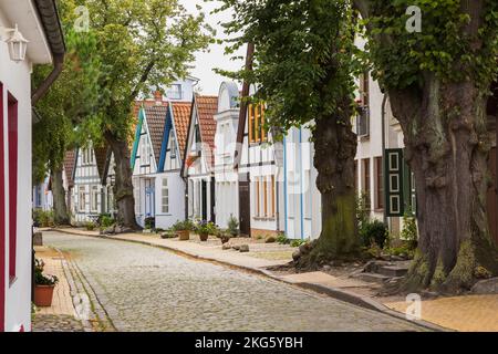 Rue résidentielle avec pavés rectangulaires et façades de maisons colorées avec toits en terre cuite, station balnéaire de Warnemunde, Allemagne. Banque D'Images