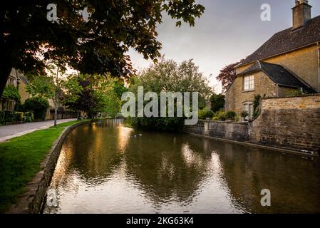 Chalet en pierre et balustrade sur la rivière Windrush à Bourton-on-the-Water dans les Cotswolds, Angleterre, une zone de conservation du Royaume-Uni. Banque D'Images