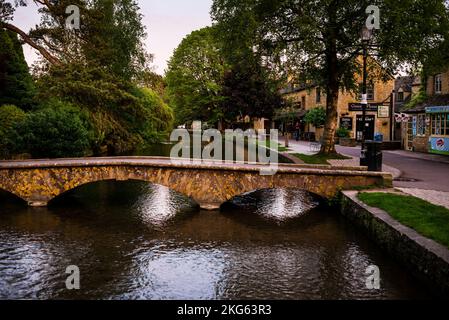 Village anglais Bourton-on-the-Water dans les Cotswolds avec des passerelles en pierre voûtées sur la rivière peu profonde Windrush. Banque D'Images