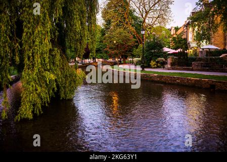 Pont piétonnier voûté en pierre sur la rivière Windrush à Bourton-on-the-Water, Cotswolds, Angleterre. Banque D'Images