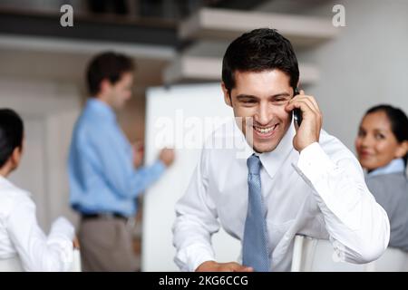 Prendre un appel client important. Un jeune cadre prenant un appel pendant une présentation d'affaires. Banque D'Images