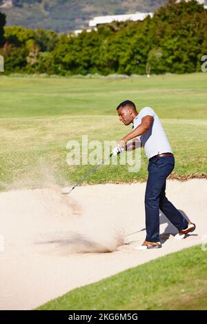 Tout est question de patience et de précision. un beau jeune homme jouant un jeu de golf. Banque D'Images