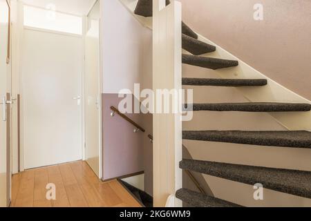 Couloir blanc avec escalier en bois menant au deuxième étage Banque D'Images