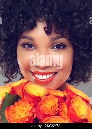 Shes un bouquet de beauté. Photo studio d'une belle jeune femme sur fond gris. Banque D'Images