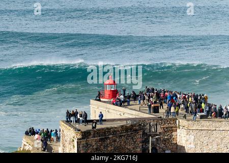 Les gens regardent les grandes vagues géantes près du phare du fort de Nazaré à Nazaré, au Portugal. Les plus grandes vagues du monde. Destination touristique. Banque D'Images