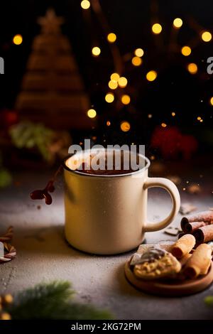 Tasse de chocolat chaud avec éclaboussures entourée de décorations de Noël Banque D'Images