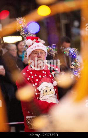 Guirlandes lumineuses de Noël sur Lockerbie, Écosse, collier de tuyaux de Lockerbie vêtu d'une robe de Noël fantaisie Banque D'Images