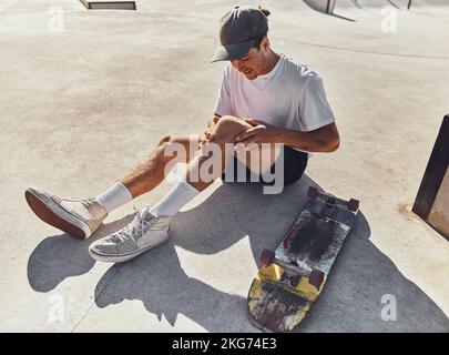 Skateboard, genou et blessure avec un sportif tenant son articulation de jambe en douleur après une chute ou un accident à l'extérieur. Fitness, skate Park et exercice avec un Banque D'Images