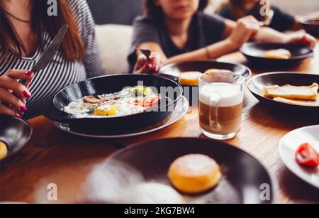 Pâtisseries, légumes, légumes verts, fromages, œufs frits, confitures et thé en pot de cuivre et des verres de tulipe sur fond de bois, vue de dessus Banque D'Images
