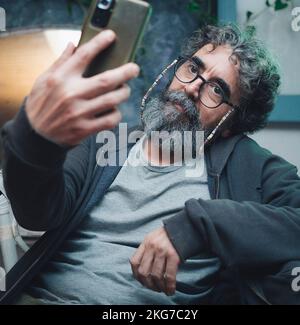 homme avec barbe prenant un autoportrait Banque D'Images