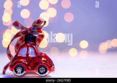 Gros plan, en forme de voiture, jouet de Noël sur un fond flou avec bokeh. Banque D'Images