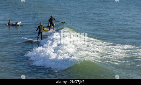 Surfeurs sur une belle journée à Bournemouth Pier 20th novembre 2022kneeling Banque D'Images