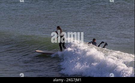 Surfeurs sur une belle journée à Bournemouth Pier 20th novembre 2022kneeling Banque D'Images